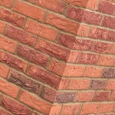 Close-up of red face brickwork with a raked, angled corner detail