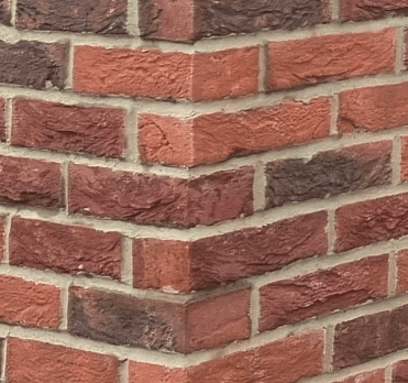 Close-up of a red brick external corner with clean, even coursing