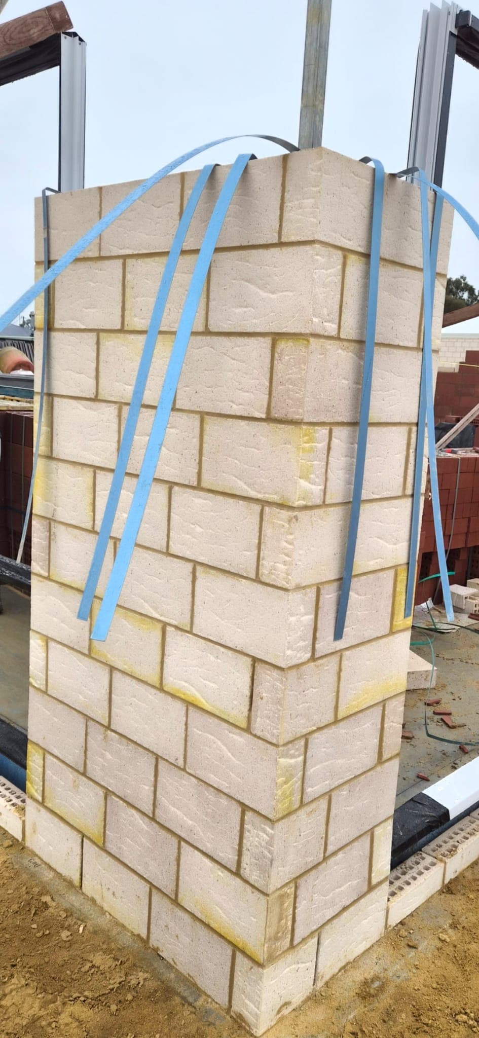 Squared-off cream block pier built up ready for the return wall