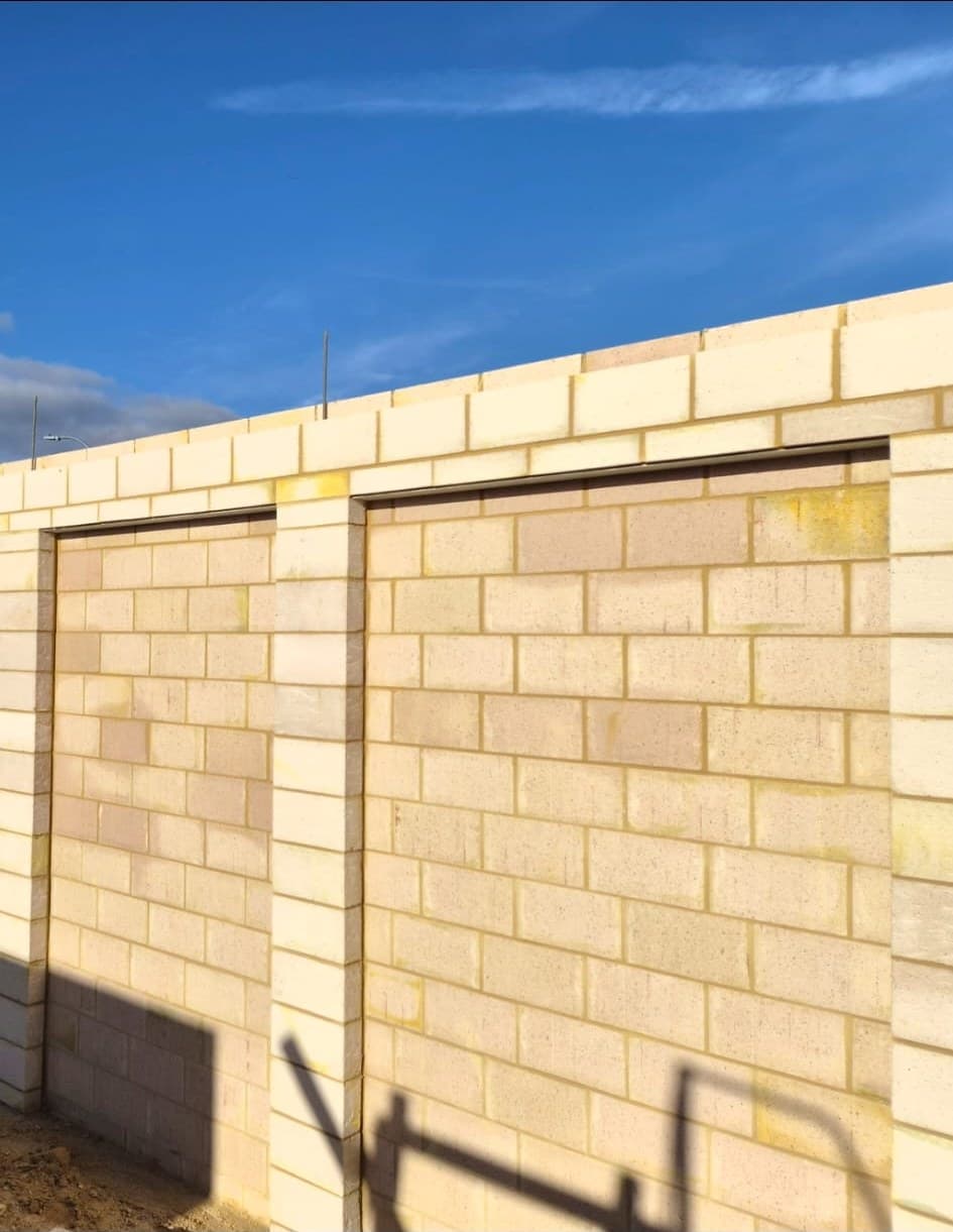 Cream block boundary wall built by Perth Brickwork Solutions, photographed against a blue sky