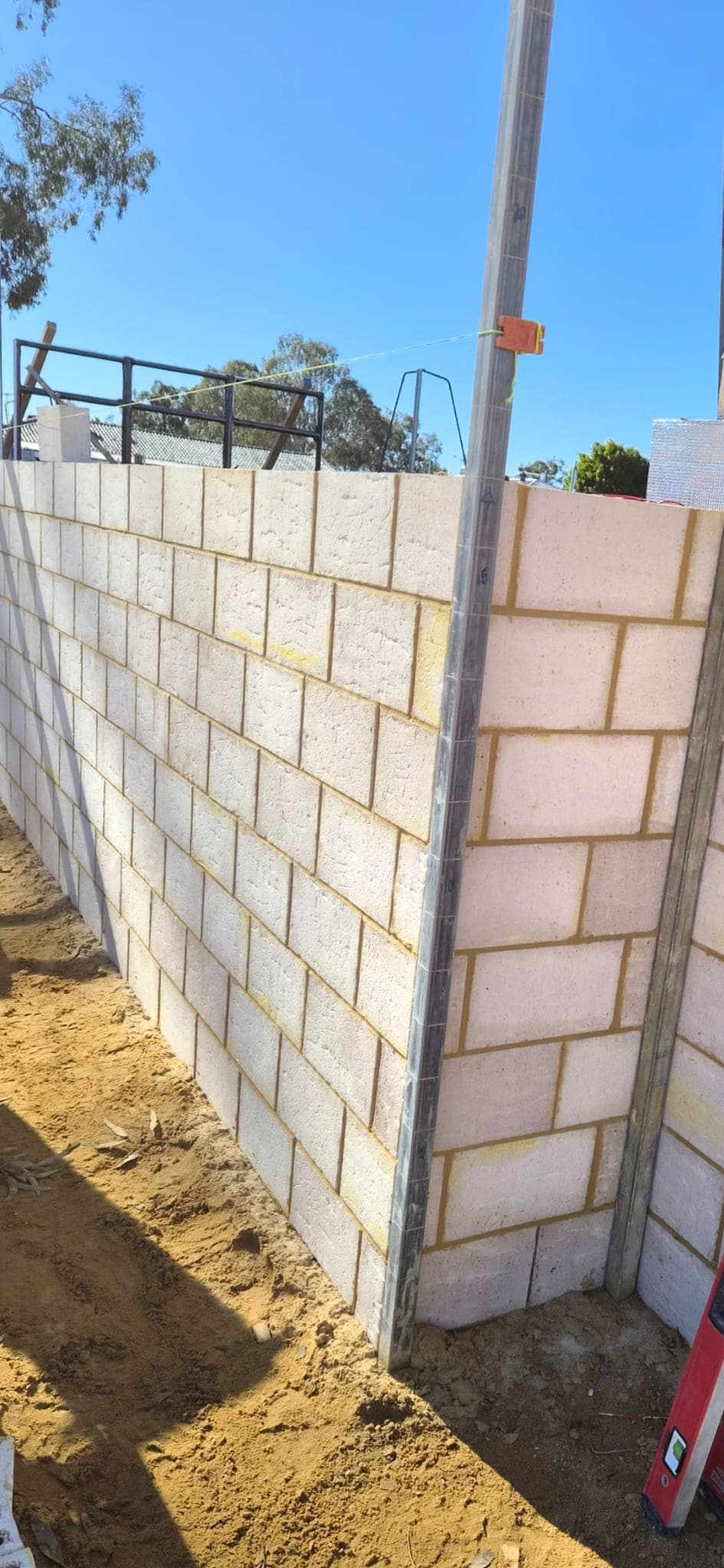 Block boundary wall being set out and plumbed with a profile and string line on site